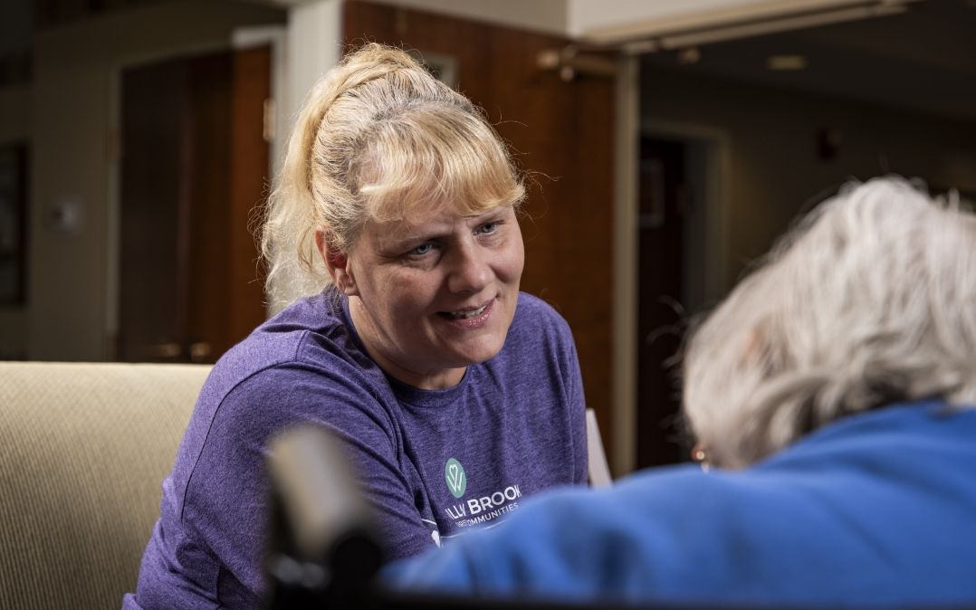 A Willow Brook Home caregiver brings warmth to her work in Columbus, Ohio, illustrating the dedicated team behind compassionate senior care.